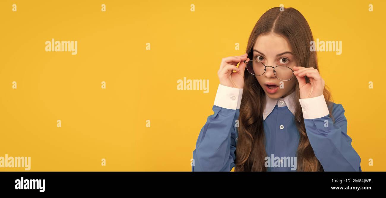 Just curious. Curious girl in eyeglasses. Nerdy-looking kid yellow background. Back to school. Child face, horizontal poster, teenager girl isolated Stock Photo