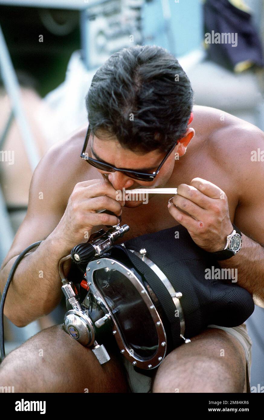 A diver prepares his diving equipment aboard the salvage ship USS PRESERVER (ARS8) during