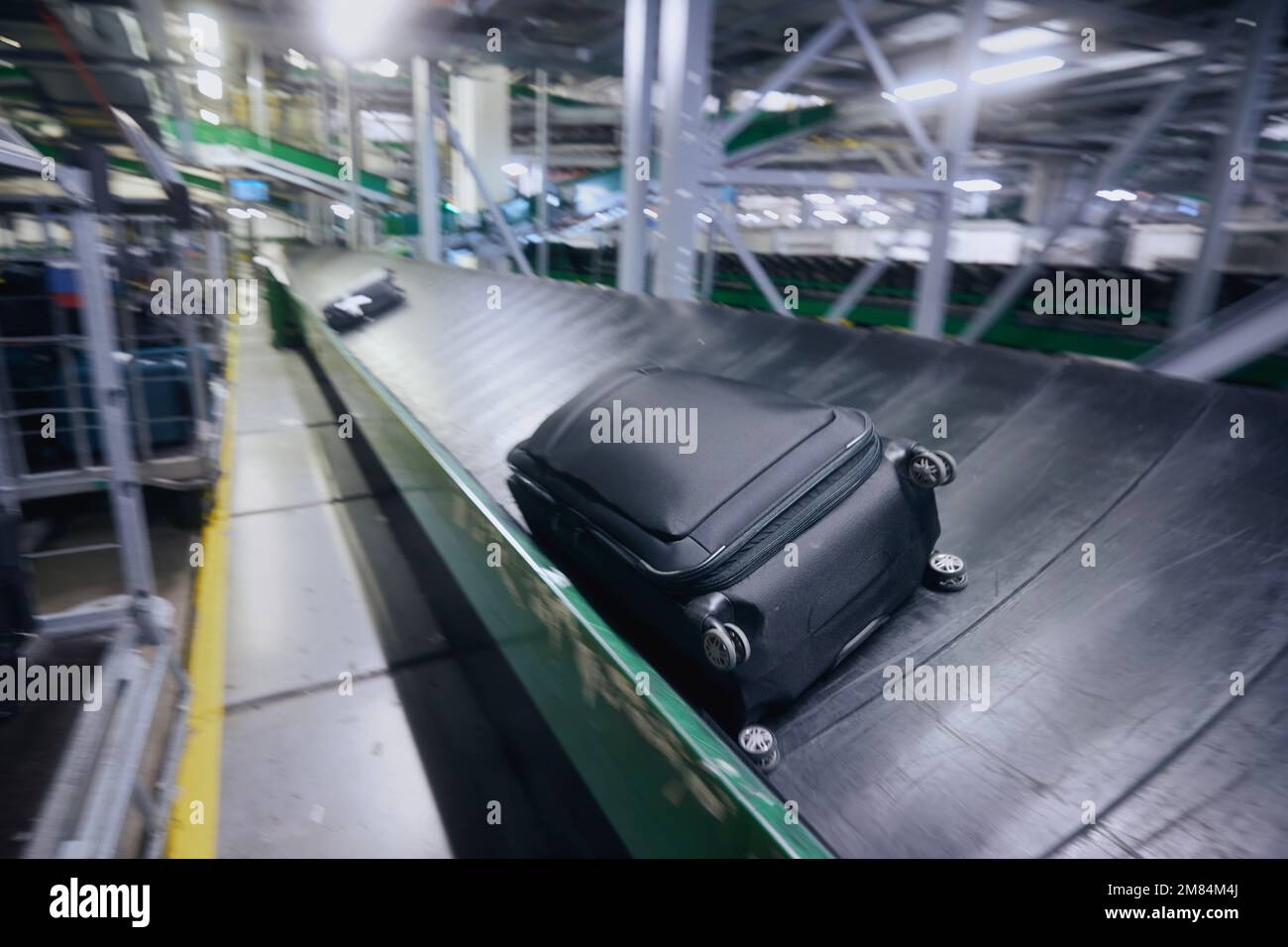 Traveling by airplane. Luggage on conveyor belt in blurred motion. Baggage sorting at airport