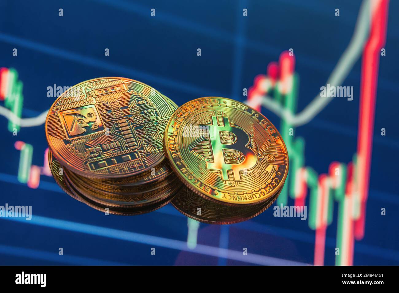 Two heaps of golden bitcoins on blue digital background with cryptocurrency chart indicating
