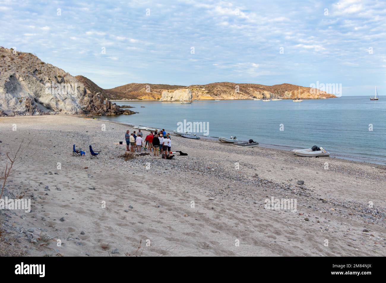 Cruising sailors on the beach for a happy hour party, dinghies on shore and boats anchored in background, San Juanico, Sea of Cortez, Baja, Mexico. Stock Photo