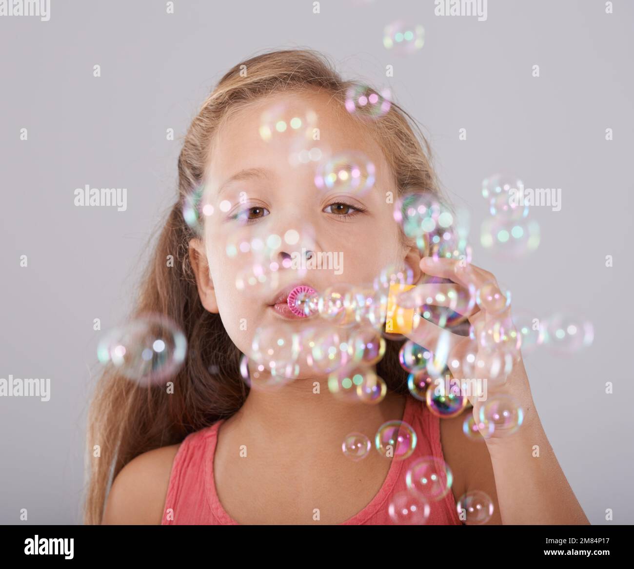 Fun with bubbles. Portrait of a cute little girl blowing bubbles Stock