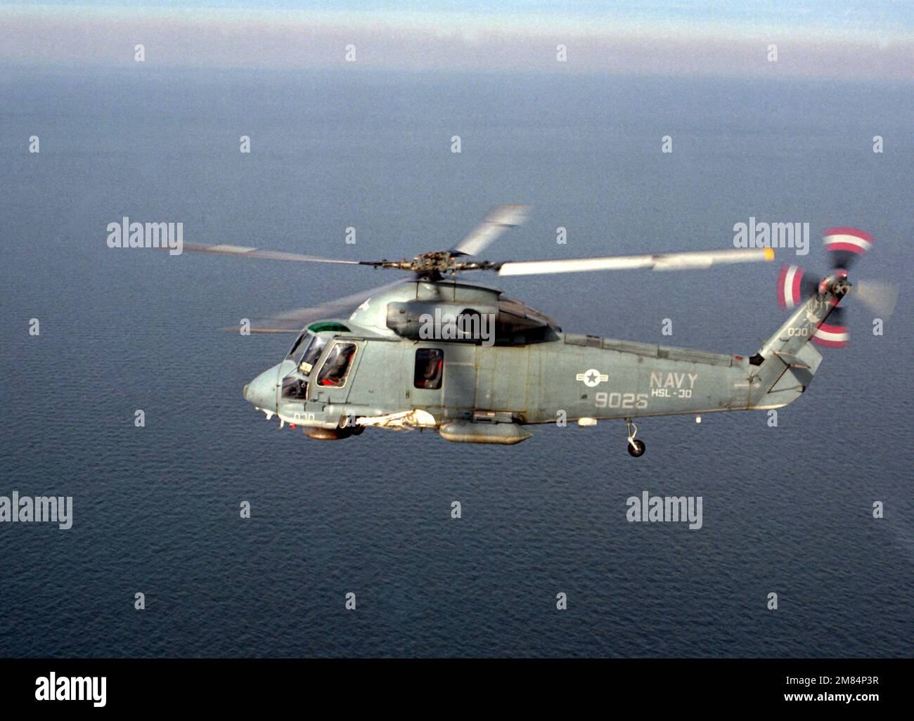 An air-to-air left side view of an SH-2F Sea Sprite helicopter of Light Helicopter Antisubmarine Squadron 30 (HSL-30). Country: Unknown Stock Photo
