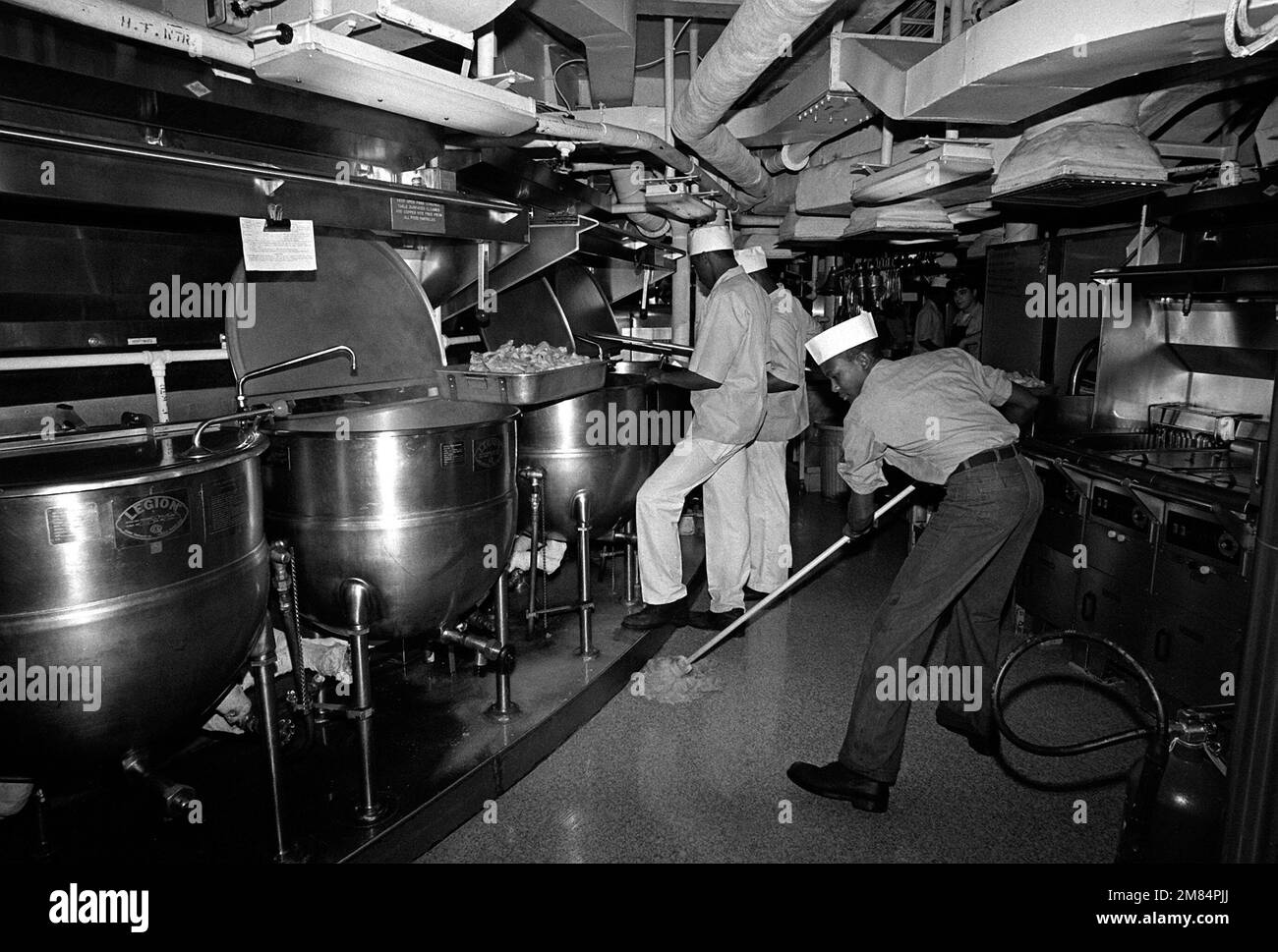 Mess Spcialists work around a semicircle of cooking kettles in the main ...