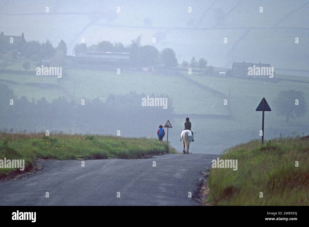 Woman on horse on moorland road in 1983, Haworth, West Yorkshire Stock Photo