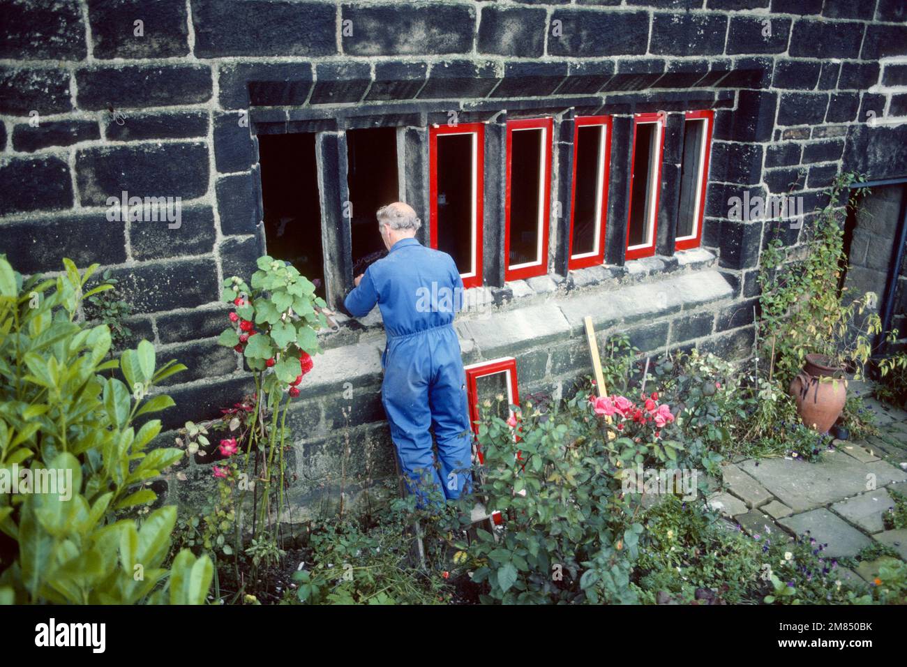 Joiner fitting new mullioned windows to 17th century farmhouse in 1985, Luddenden Foot, West Yorkshire Stock Photo