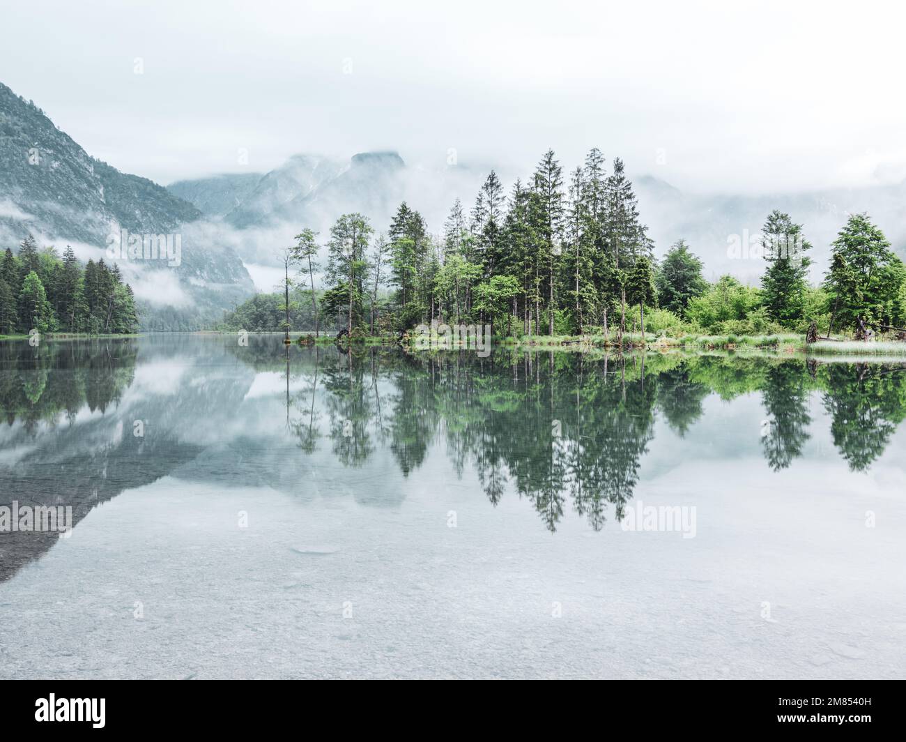 A beautiful shot of lake Alm reflecting the environment near the village Grunau im Almtal Stock Photo