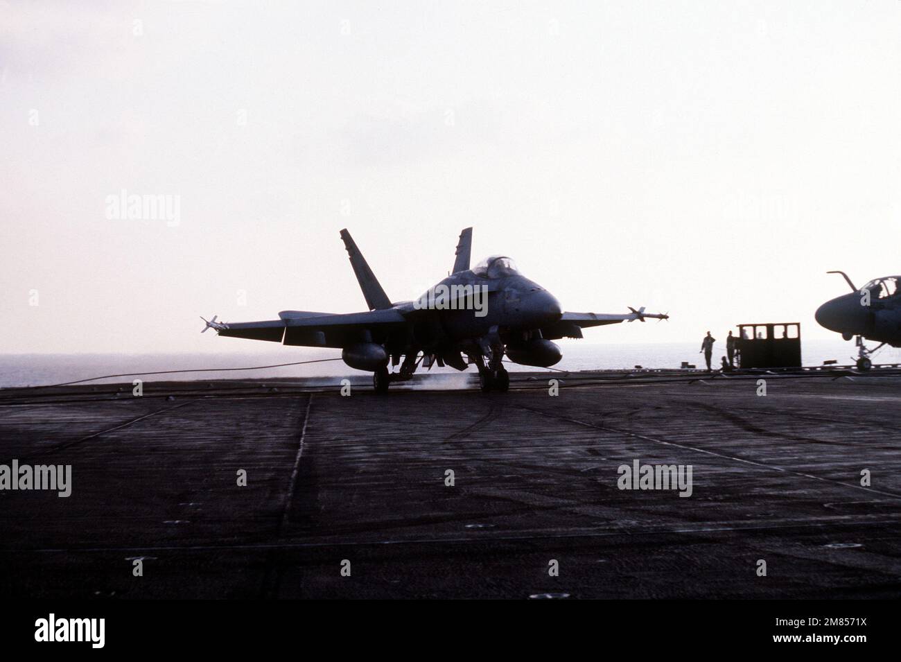 A Marine Stirke Fighter Squadron 314 (VMFA-314) F/A-18A Hornet aircraft is restrained by an arresting cable shortly after landing aboard the aircraft carrier USS CORAL SEA (CV-43). Country: Central Mediterranean Stock Photo