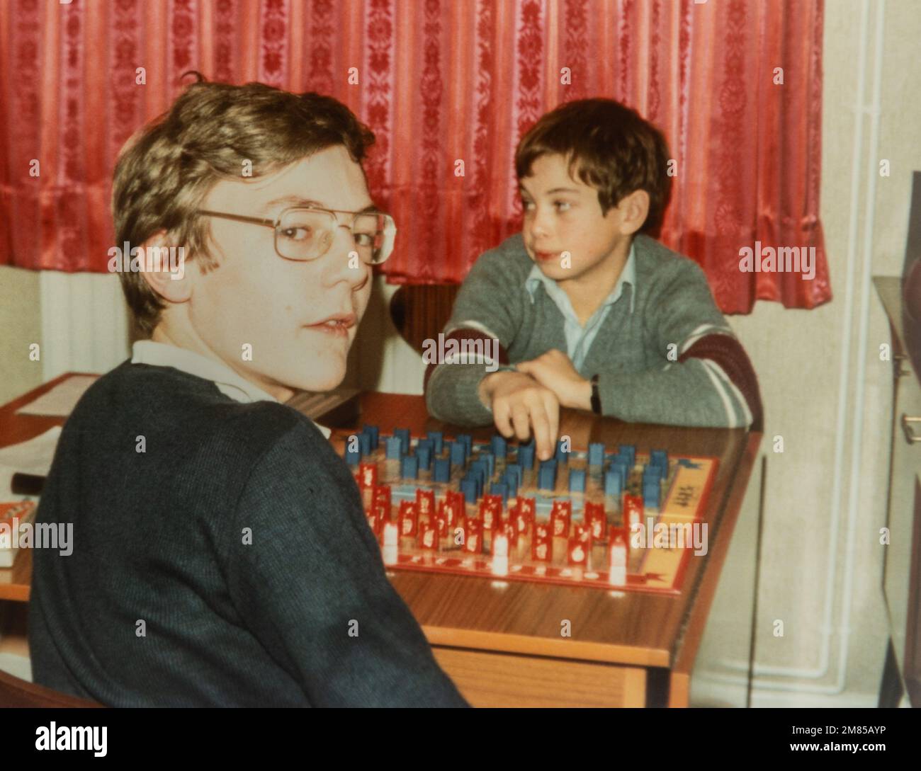 Two boys children kids playing Guess Who board game, archival photo from around 1982, England, UK Stock Photo