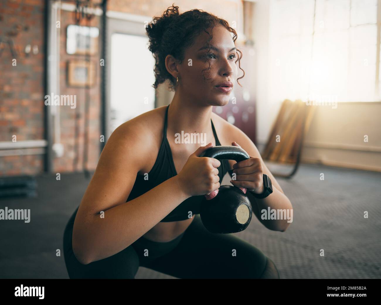 Exercise, kettlebell and a woman at gym breathing during workout, exercise and weight training for body wellness. Strong sports female or athlete with Stock Photo