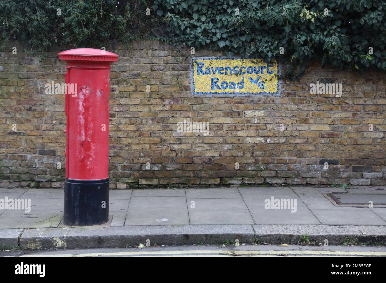 Red Royal Mail postbox and mosaic sign for Ravenscourt Road. Stock Photo