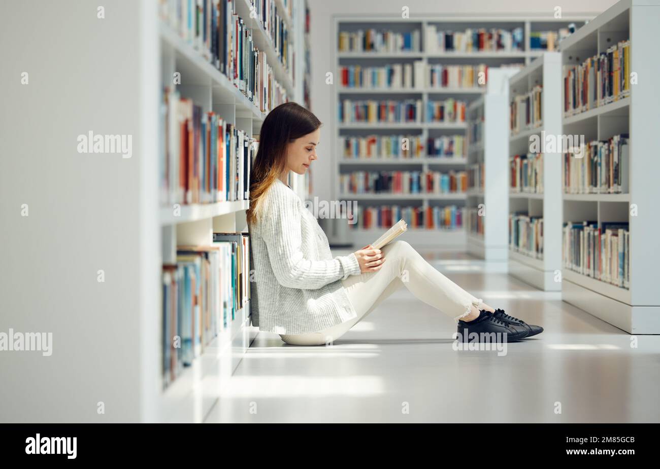 Reading, knowledge and woman with a library book for education, research and learning at college. Scholarship, academy and student with books for Stock Photo