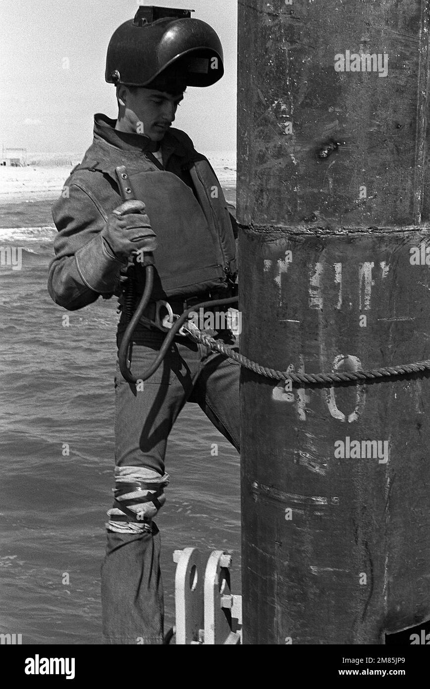 Steelworker Constructionman Grant Ramey, Amphibious Construction Battalion 2, welds a pier piling during Exercise ELCAS (Elevated Causeway), a training exercise in which Seabees learn pier-construction techniques. Subject Operation/Series: ELCAS (ELEVATED CAUSEWAY) Base: Naval Air Station, Norfolk State: Virginia (VA) Country: United States Of America (USA) Stock Photo