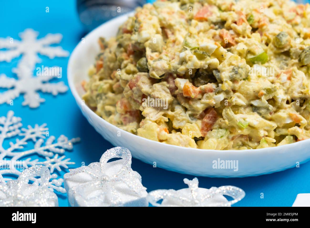 Olivier Russian salad, Christmas and New Year food, blue background, top view. Stock Photo