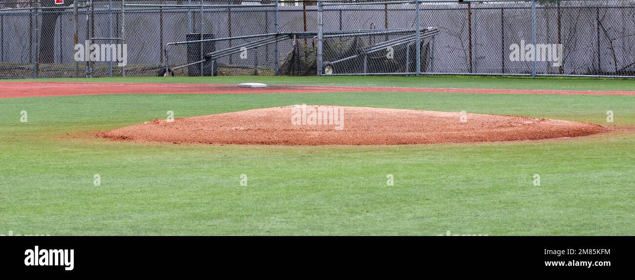 An empty turf baseball field looking over the pitchers mound to first