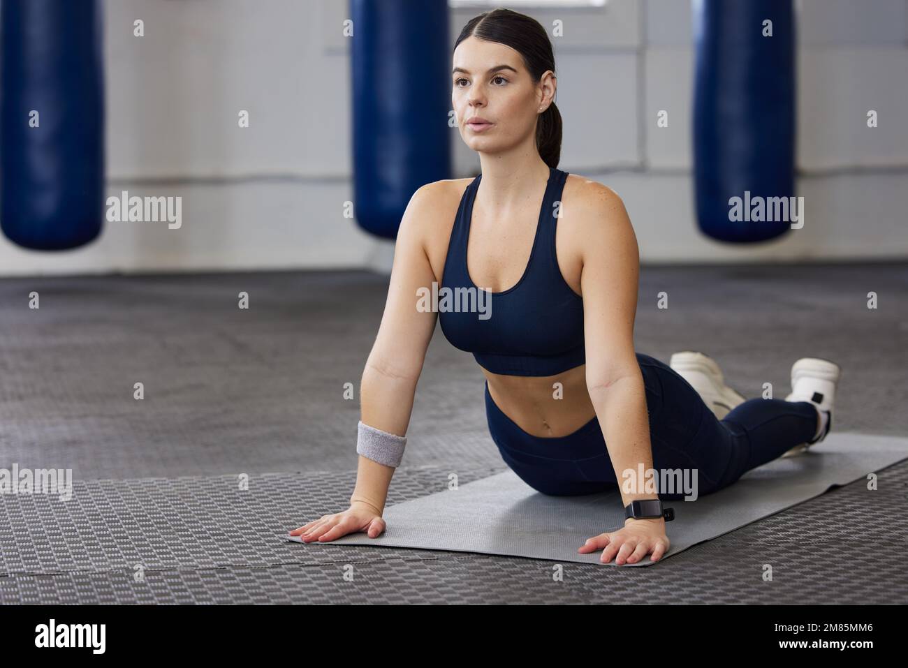 Woman, yoga fitness and stretching in gym for exercise workout, sports wellness training and pilates warm up. Zen motivation, performance breathing Stock Photo