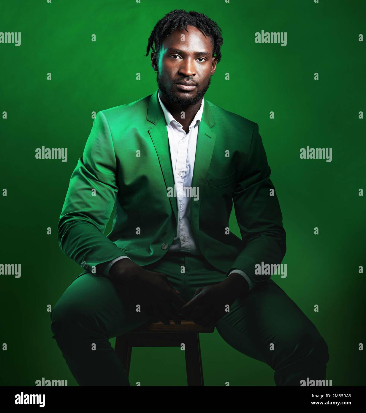 Fashion, formal and portrait of a black man in a suit sitting on a chair in studio with a luxury outfit. Elegant, stylish and African male model with Stock Photo