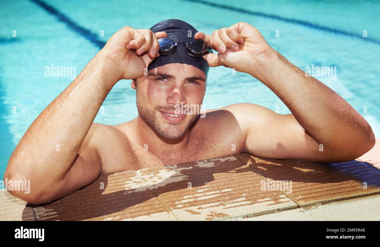 Hes done his training for the day. A handsome young swimmer wearing goggles and a swimming cap. Stock Photo