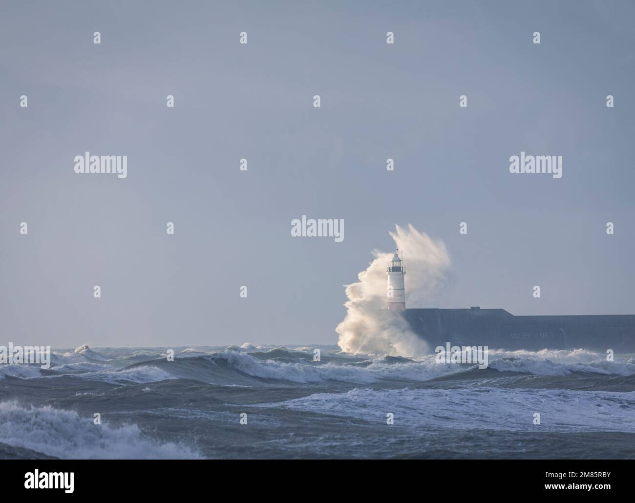 Crashing waves on a windy winters day at Newhaven lighthouse looking west from Seaford East Sussex south east England Stock Photo