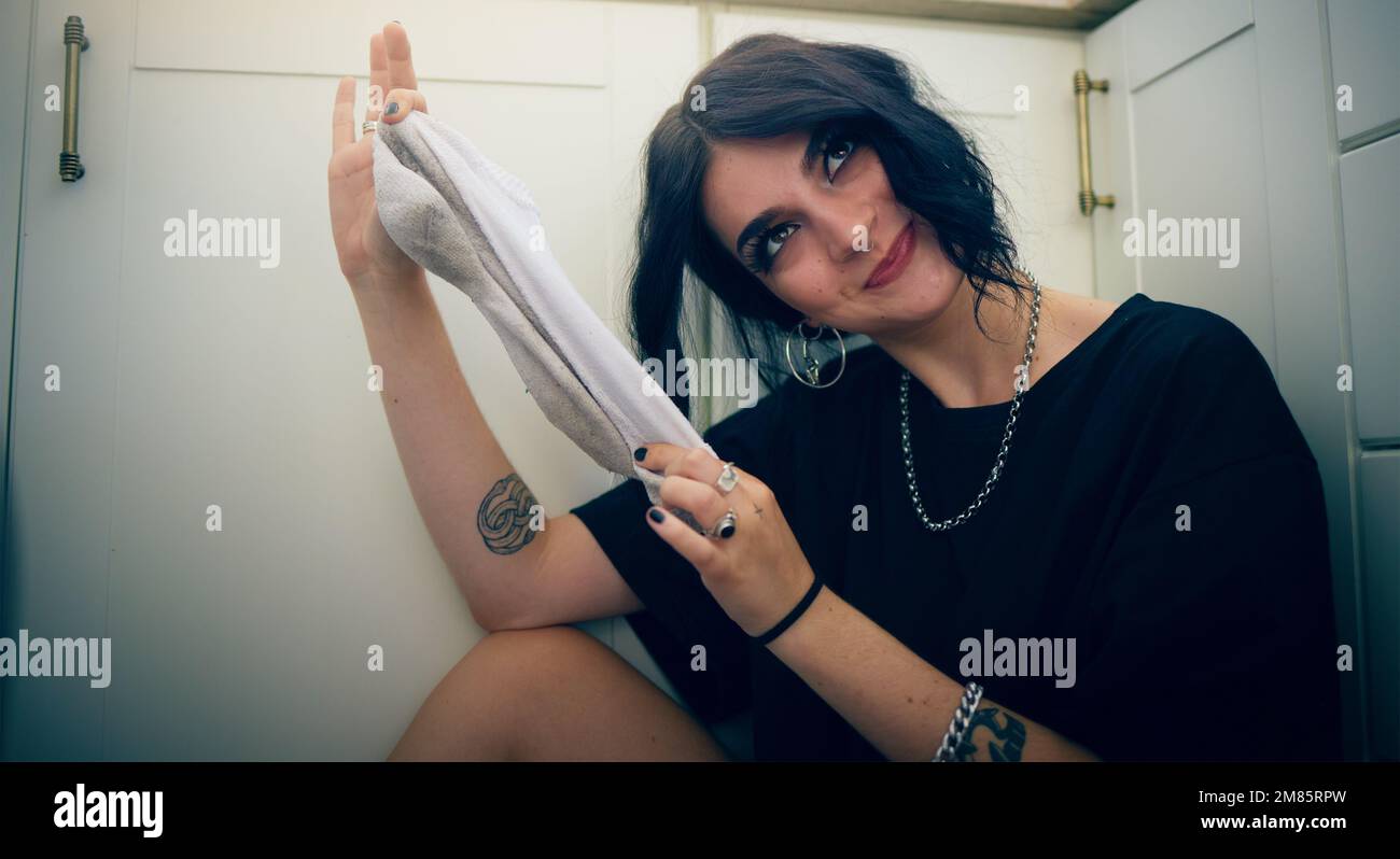 Young girl with socks, laundry and funny face, cleaning and hygiene with house work, routine and comic at home. Spring cleaning, cleaner service and Stock Photo