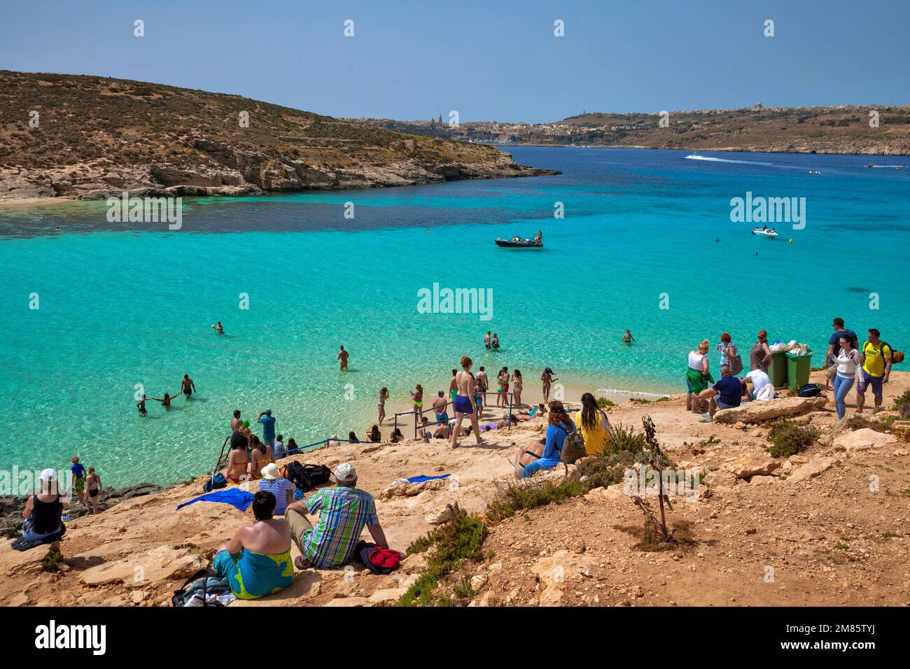 Tourists bathing in the Blue Lagoon, in the background the island of Gozo, Comino, Malta, Europe Stock Photo