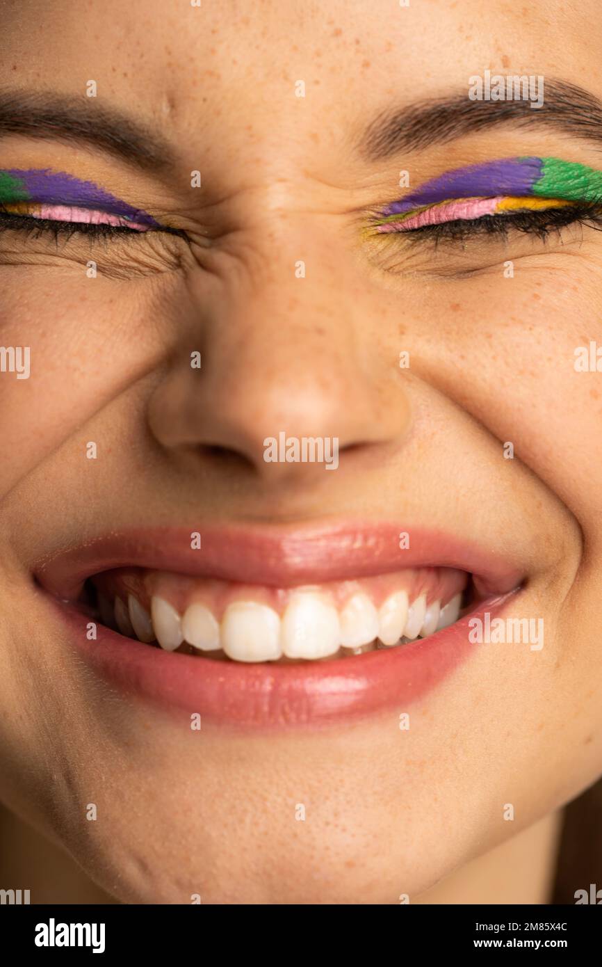 Cropped view of cheerful teen model with colorful makeup and freckles Stock Photo