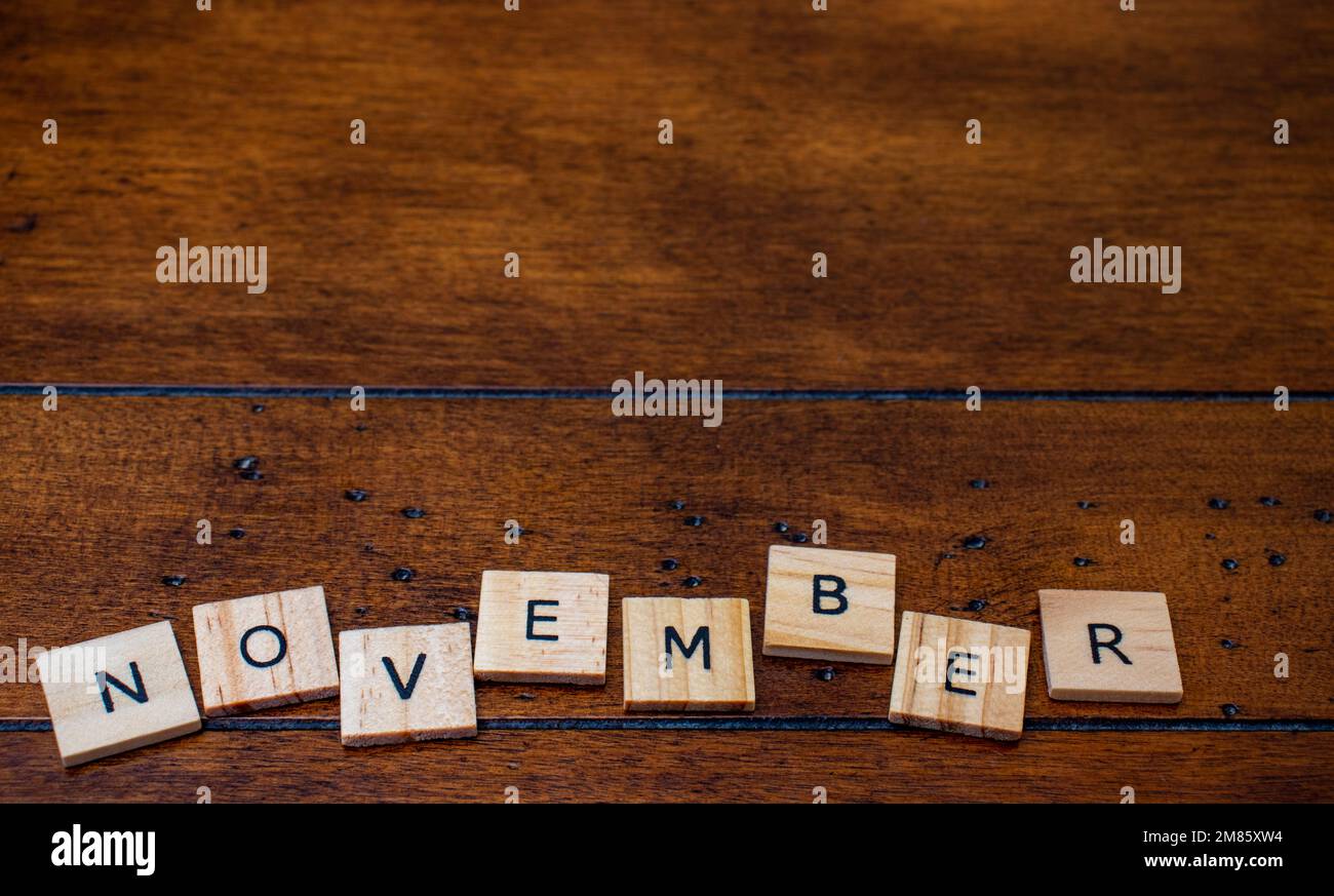November word on letter tiles on wooden background with copy space Stock Photo