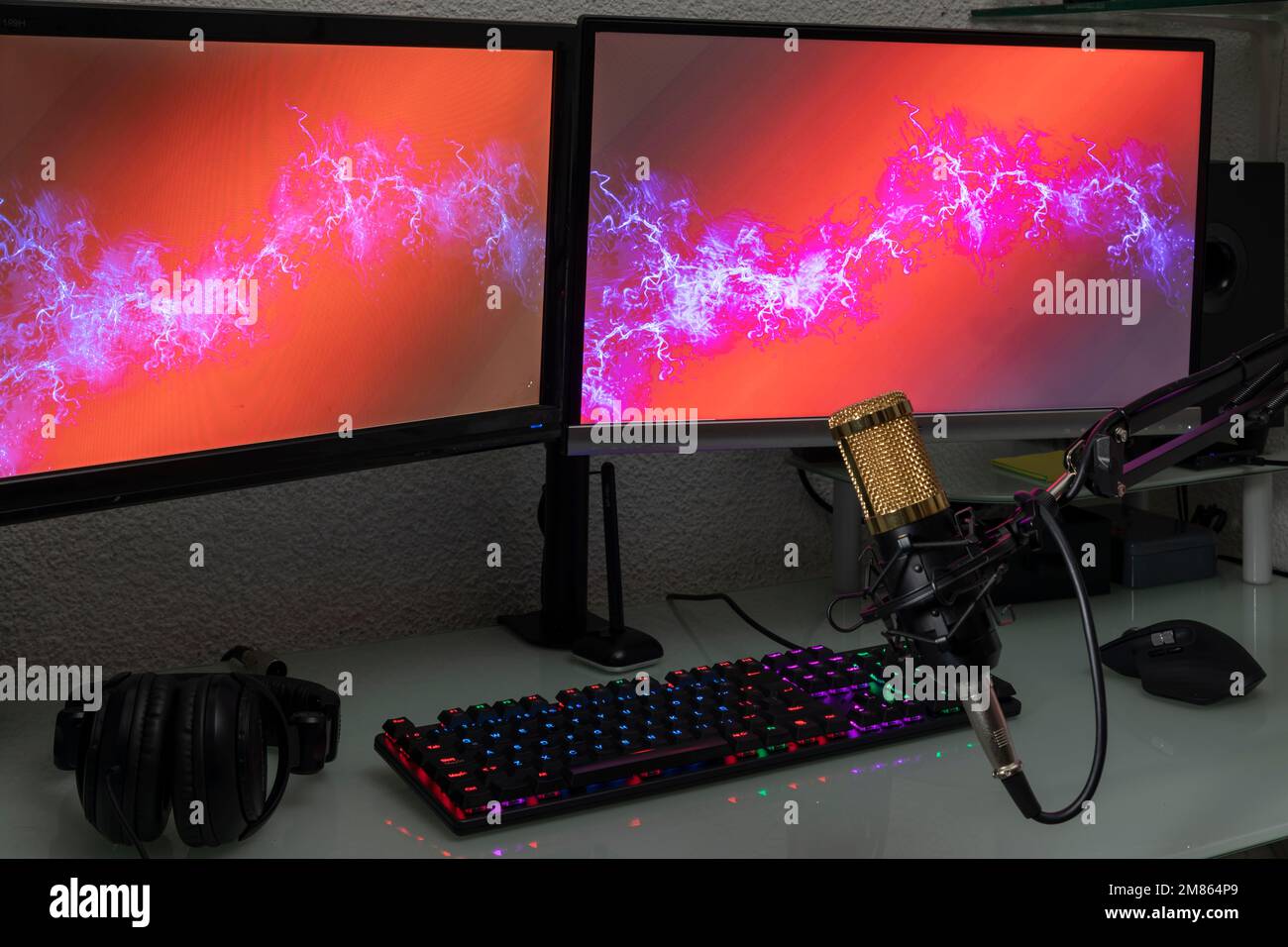Professional microphone with gamer workstation in the background and headphones. Stock Photo