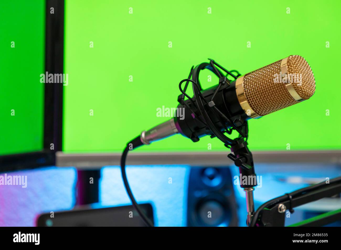 workstation with microphone and monitors with green screen for montage. Stock Photo