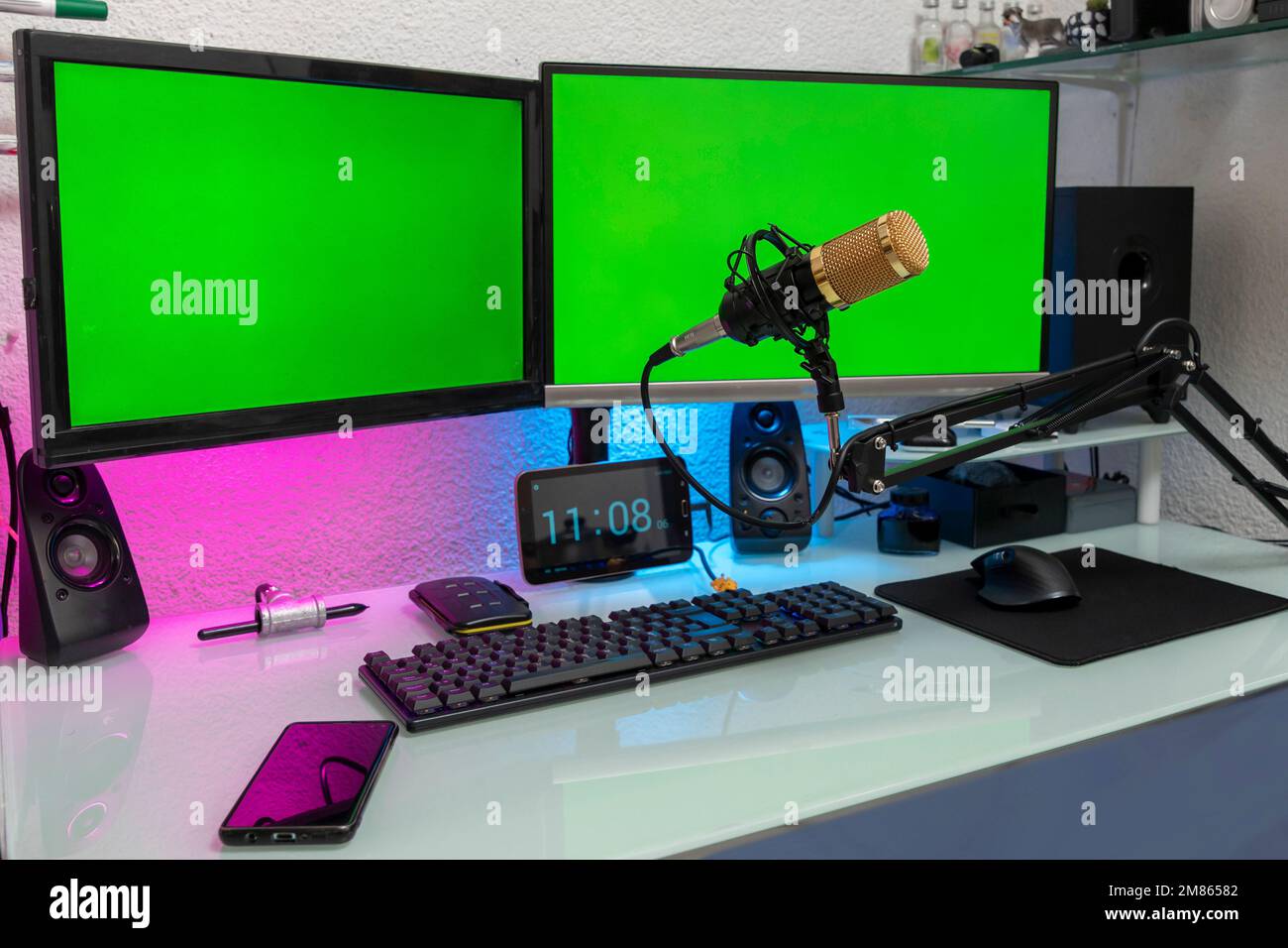workstation with microphone and monitors with green screen for montage. Stock Photo