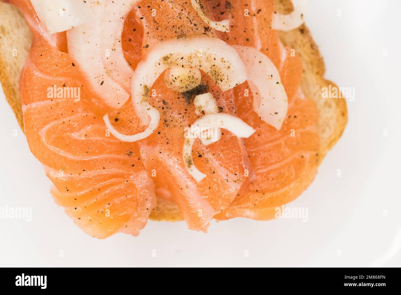 Bread with fresh salted salmon fillet isolated on white background, top view Stock Photo