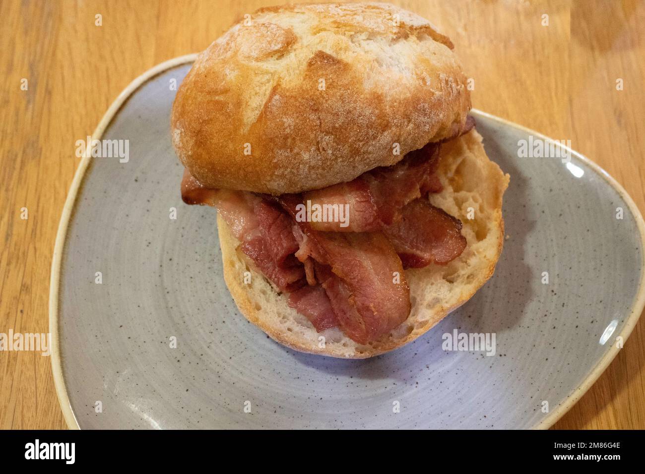 Lunchtime snack in a Yorkshire  café, grilled Bacon in a sourdough Roll Stock Photo