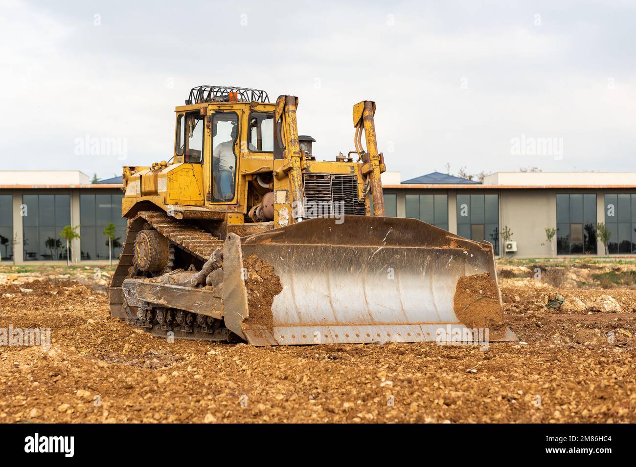 Dozer working at construction site. Bulldozer for land clearing, grading, utility trenching and foundation digging. Crawler tractor and earth-moving e Stock Photo