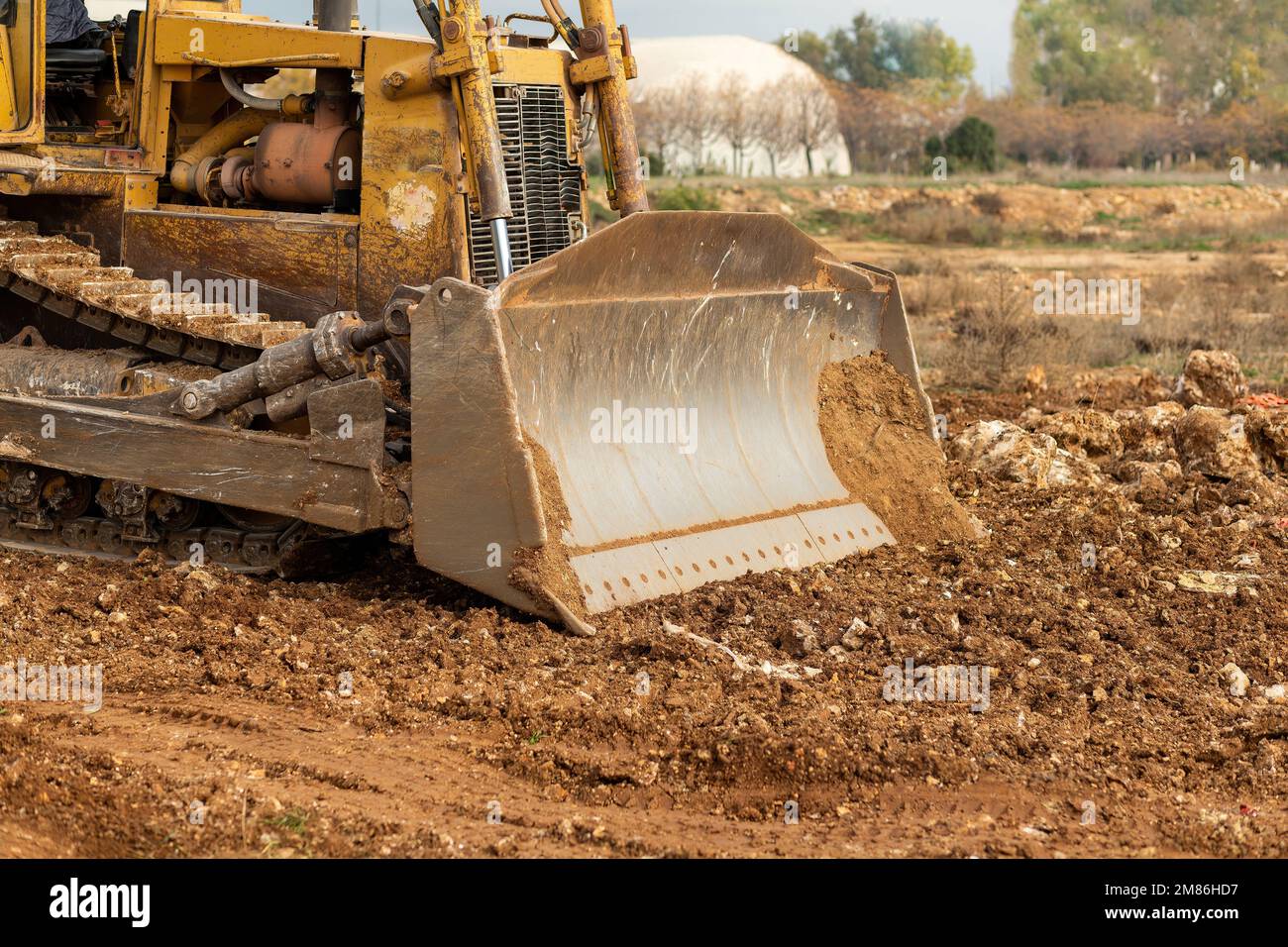 Dozer working at construction site. Bulldozer for land clearing, grading, utility trenching and foundation digging. Crawler tractor and earth-moving e Stock Photo
