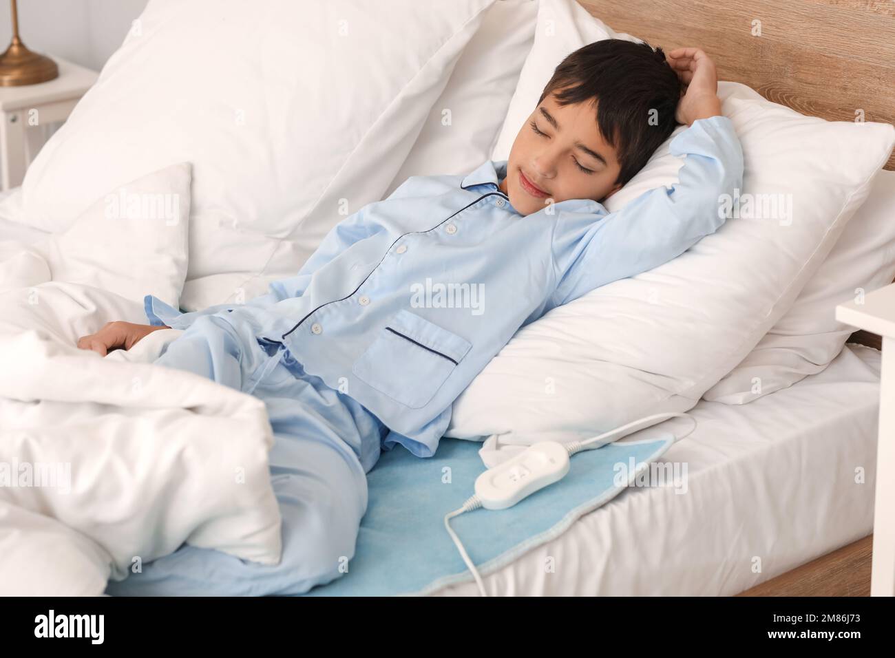 Little boy sleeping on electric heating pad in bedroom Stock Photo Alamy
