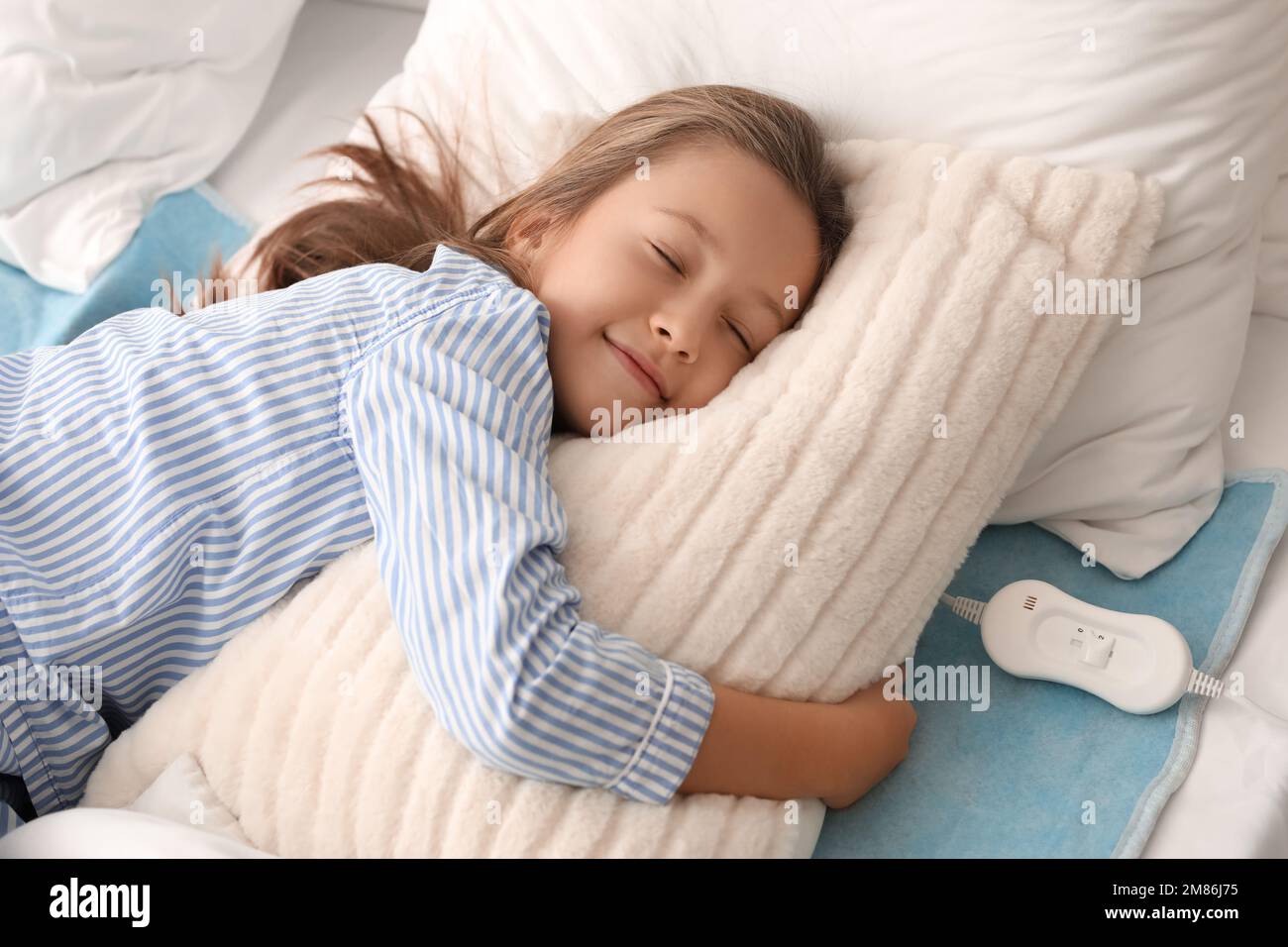 Little girl sleeping on electric heating pad in bedroom Stock Photo - Alamy