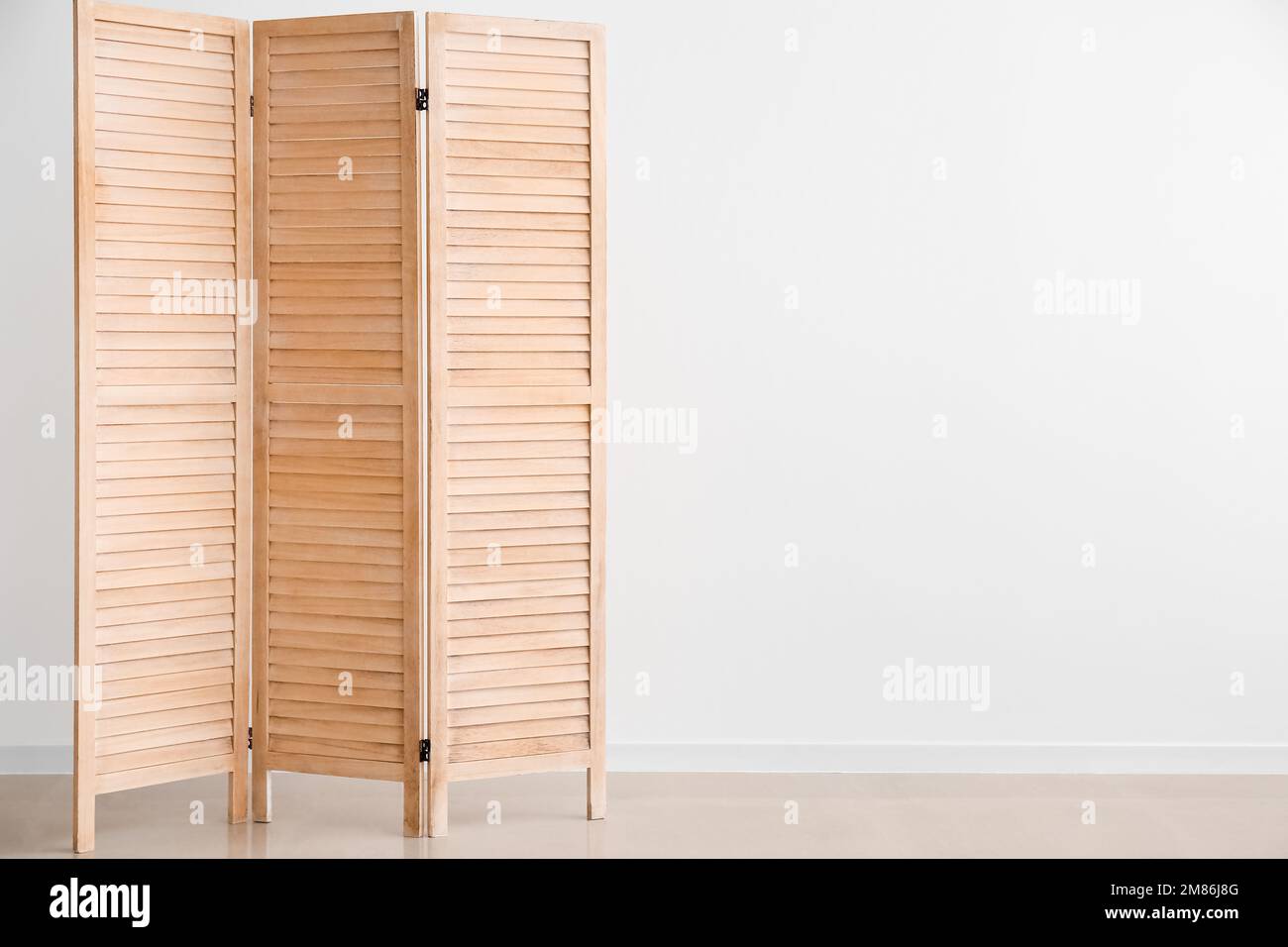 Wooden folding screen near white wall Stock Photo Alamy