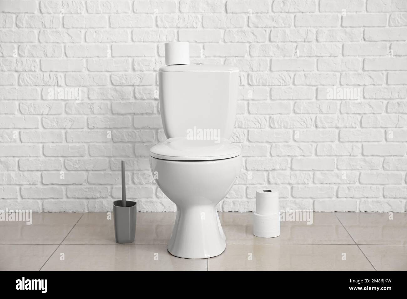 Modern toilet bowl near white brick wall Stock Photo Alamy