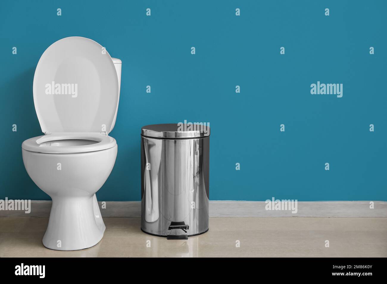 Ceramic toilet bowl and bin near blue wall Stock Photo Alamy