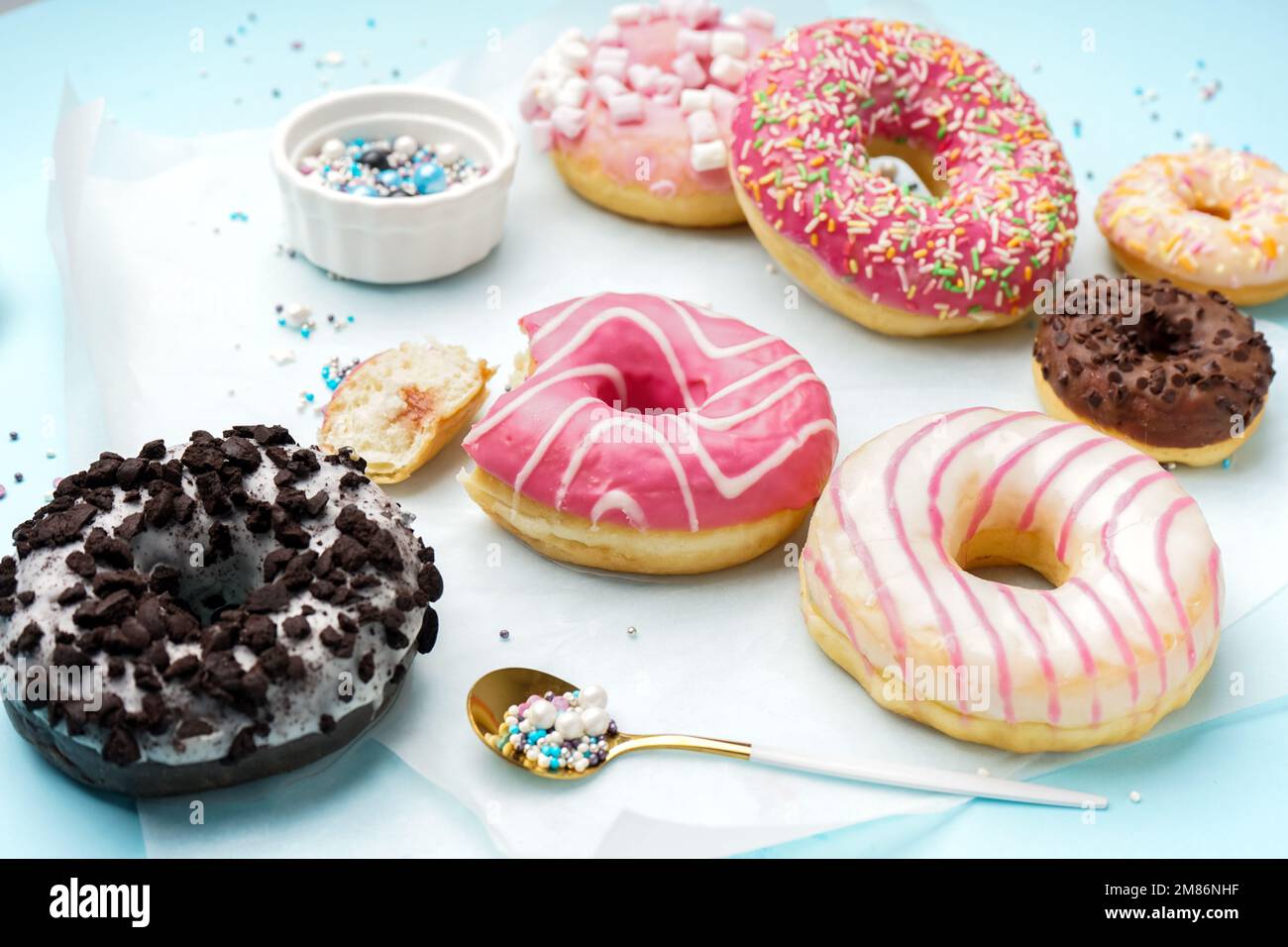 Parchment with different delicious donuts on blue background Stock Photo