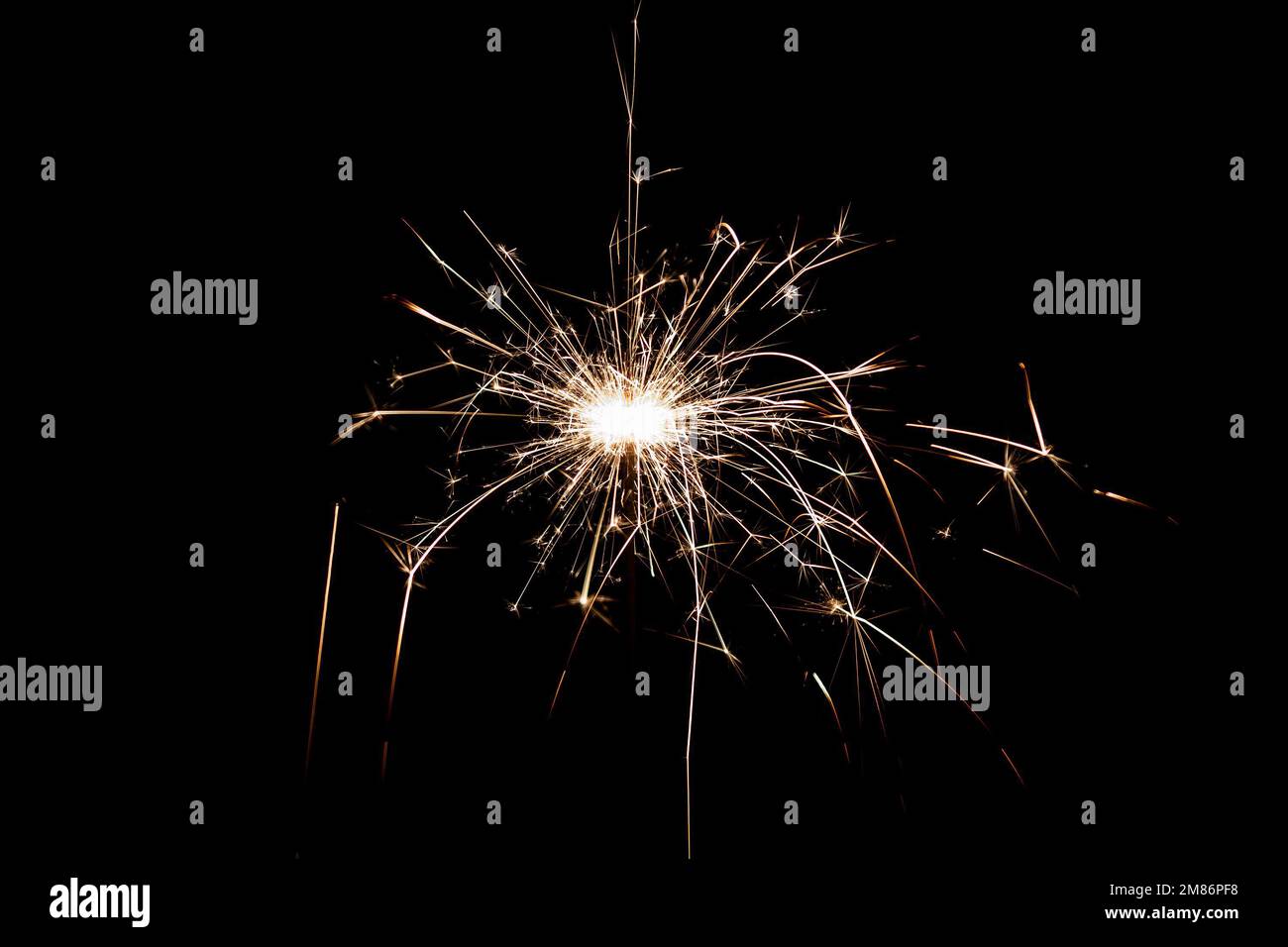 Burning sparkler isolated on black background. Fireworks theme. Light effect and texture. Christmas and new year decoration. Stock Photo