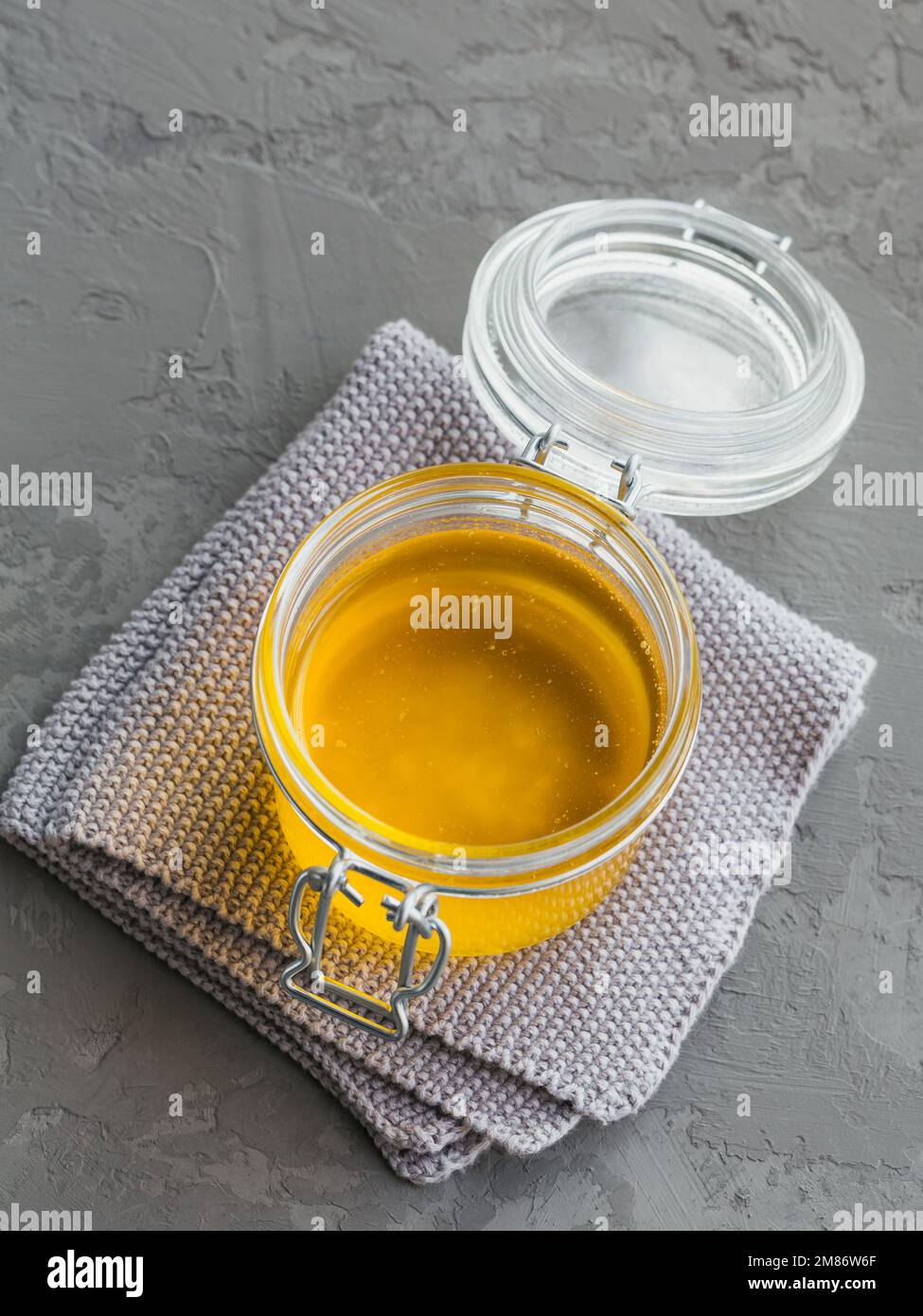 Healthy homemade Ghee or clarified butter in a jar on grey concrete