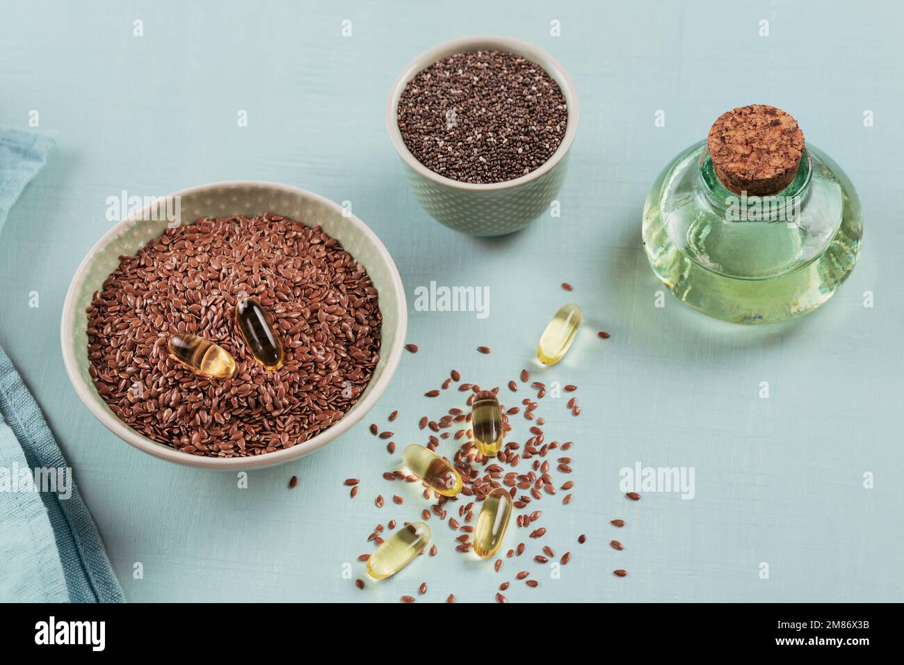 Brown flax seed or linseed and chia in small bowl and gelatin capsules