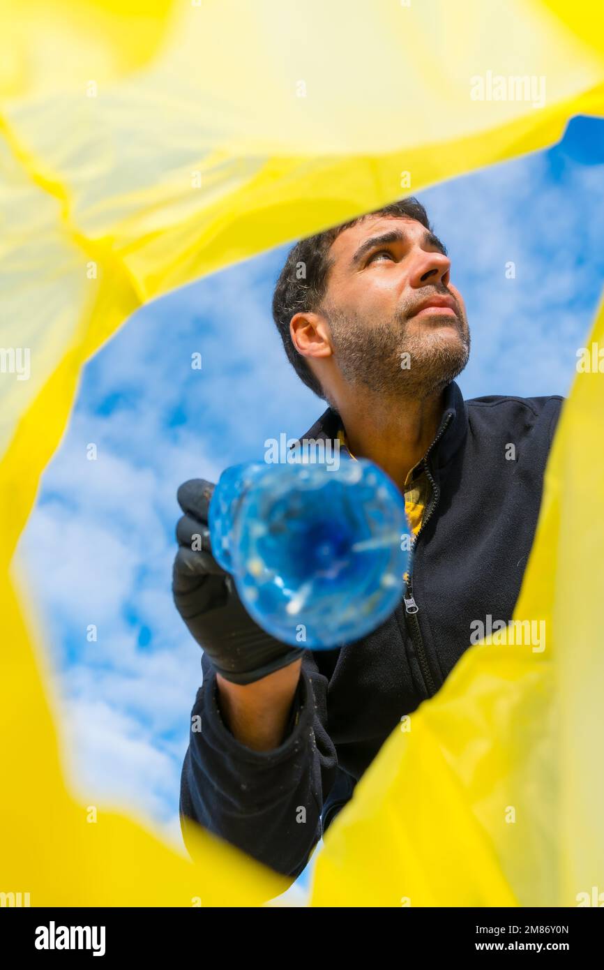 A low-angle shot of the Volunteer throwing a plastic bottle into a ...