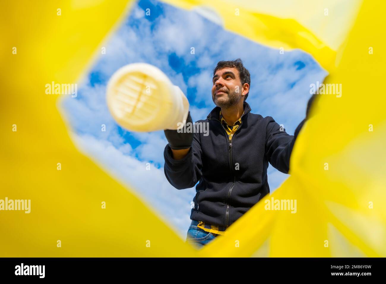 A low-angle shot of the Volunteer throwing a plastic bottle into a ...