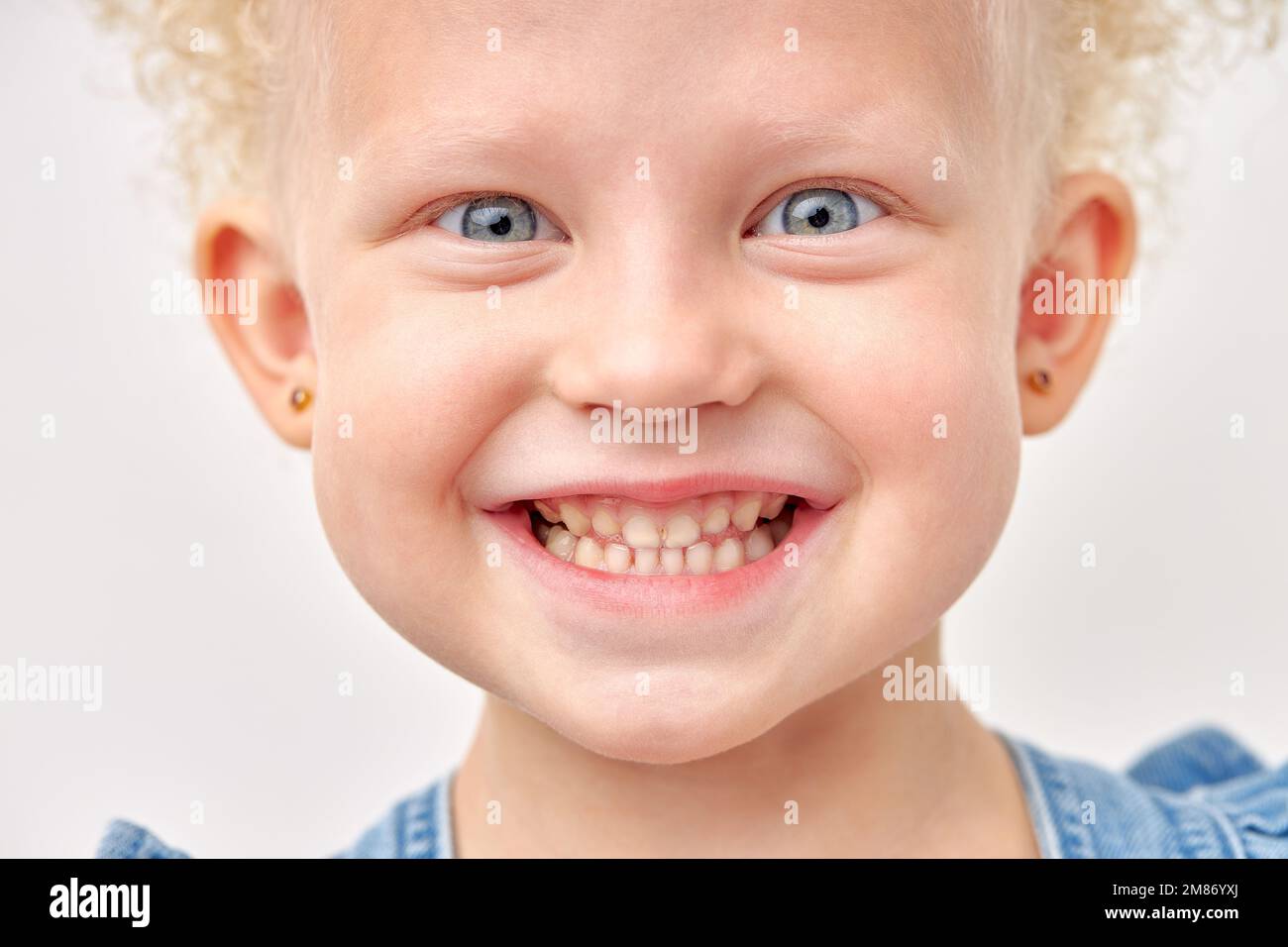 Surprise, excitement and fascination concept. Funny big blue eyed girl smiling, happy with astonishing unexpected news, having amazed look, showing fu Stock Photo