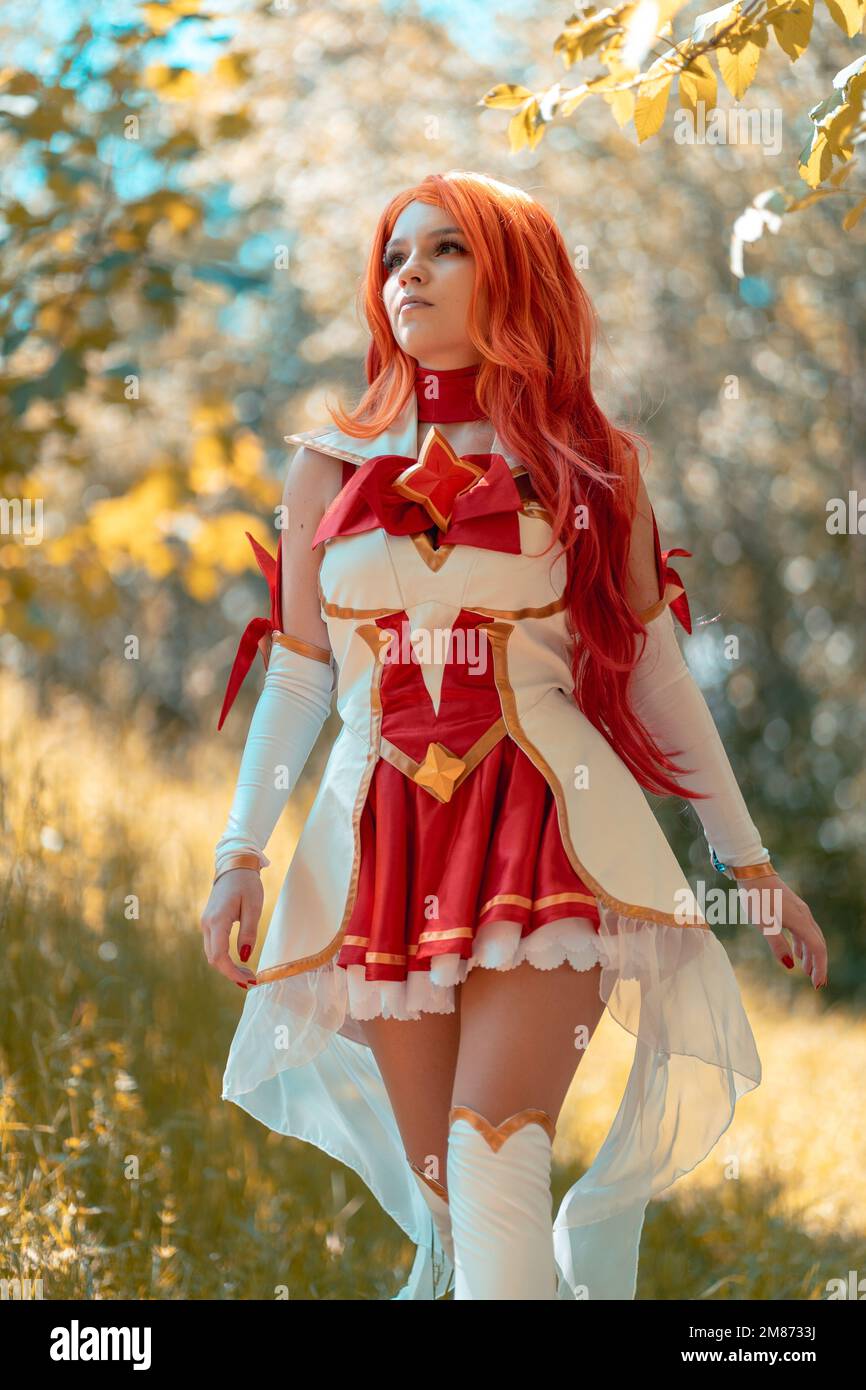 A vertical shot of a Caucasian female in miss fortune cosplay costume walking in the woods Stock Photo