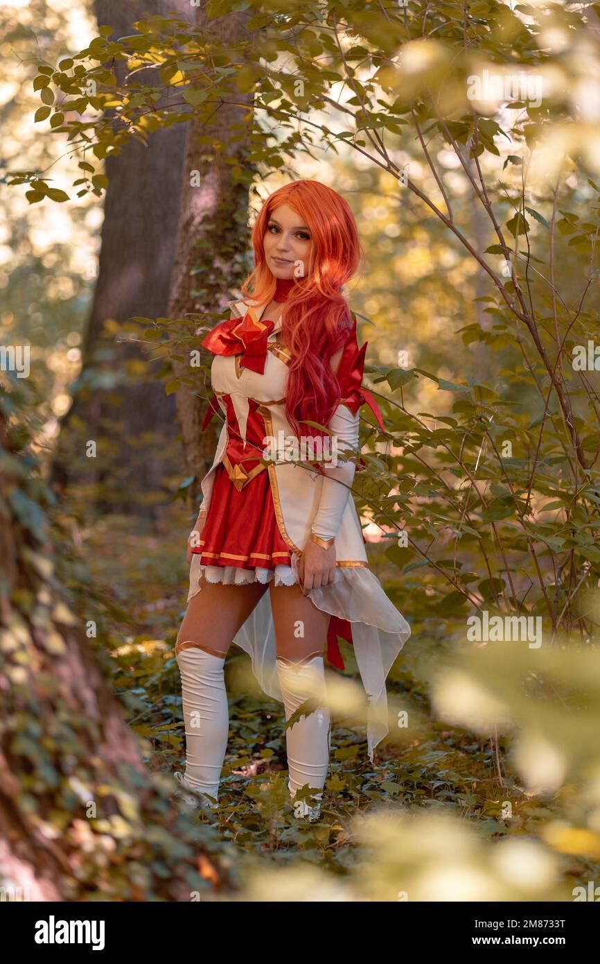 A vertical shot of a Caucasian female in miss fortune cosplay costume walking in the woods Stock Photo