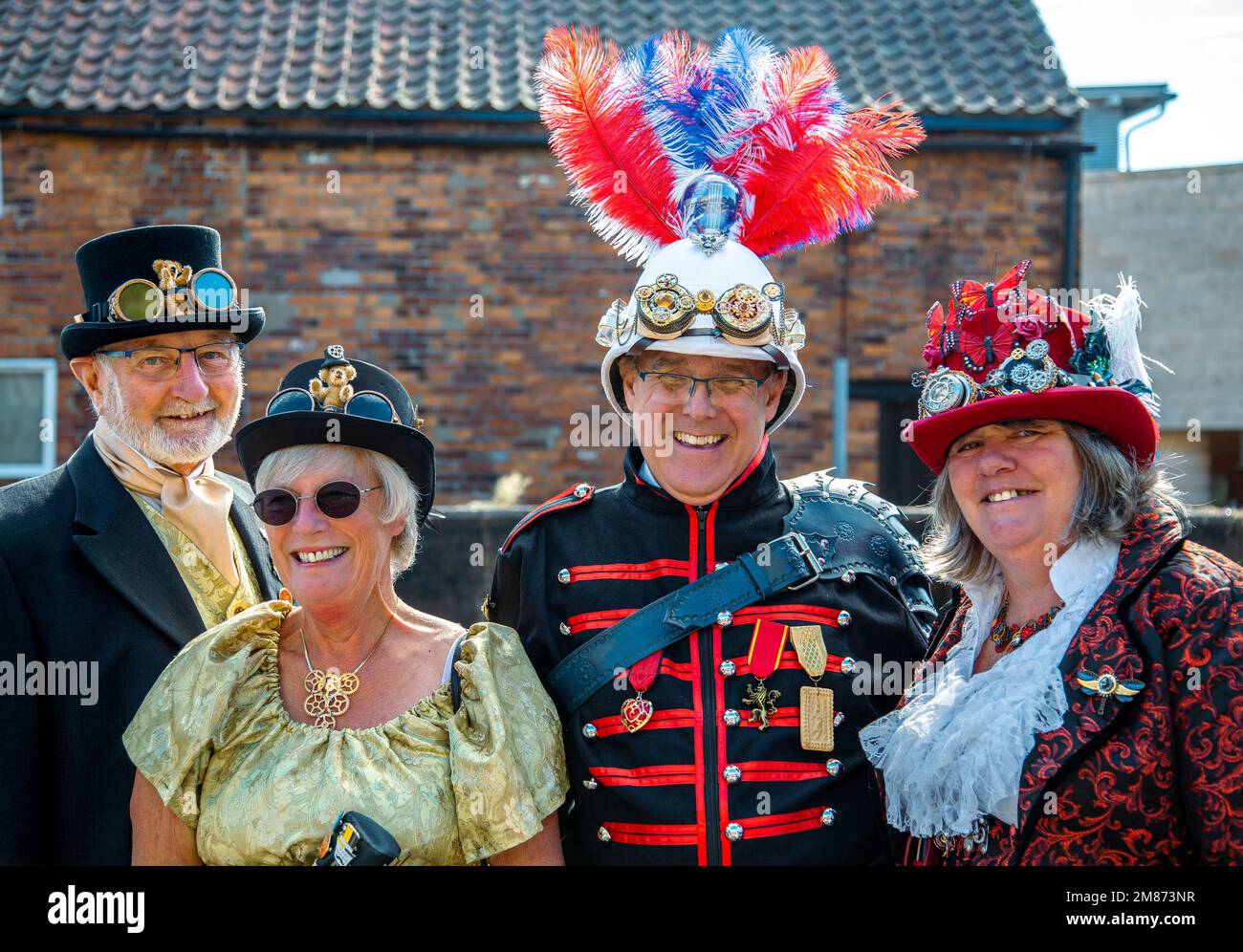 Portrait of a middle aged group of steampunks wearing period and military Steampunk clothing. Smiling, laughing and looking directly into camera. Stock Photo