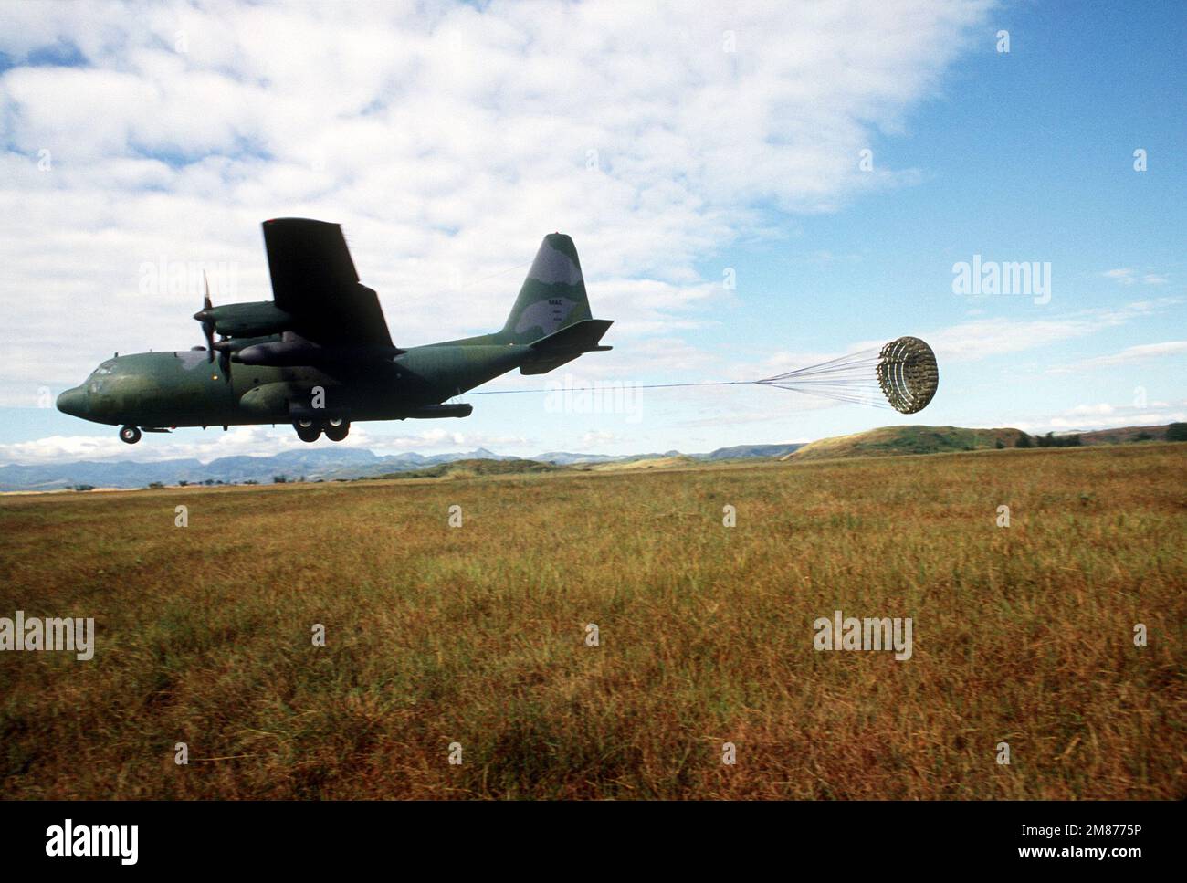 A C130 Hercules aircraft releases a drogue chute as members of the